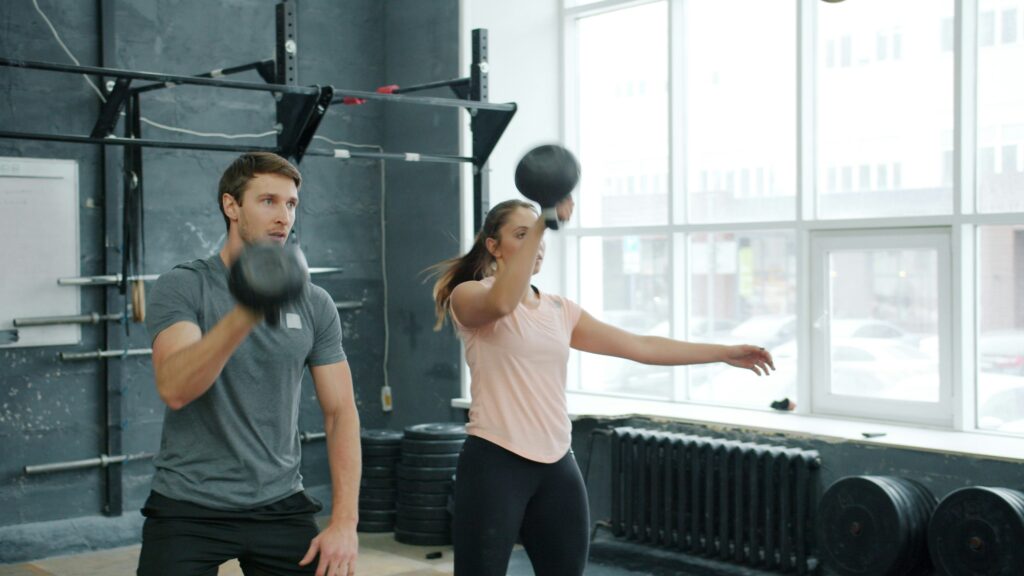 Man and woman exercising with weights in gym. Man and woman exercising with weights in gym.