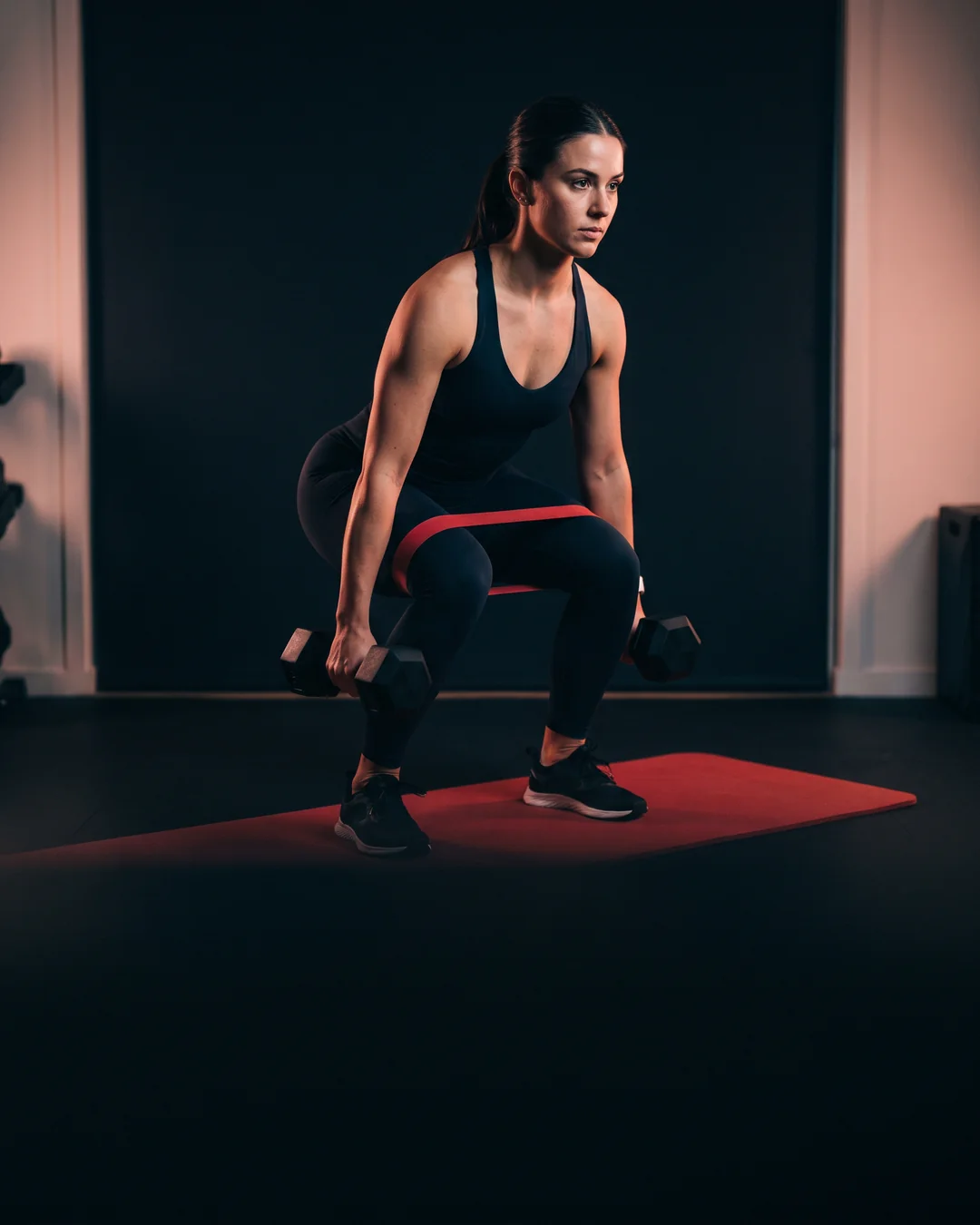 Woman lifting dumbbells in a home gym